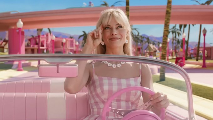 Margot Robbie de Barbie em um carro rosa