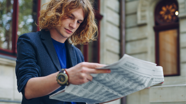 Homem lendo jornal mostrando preferencia pela comunicação impressa.