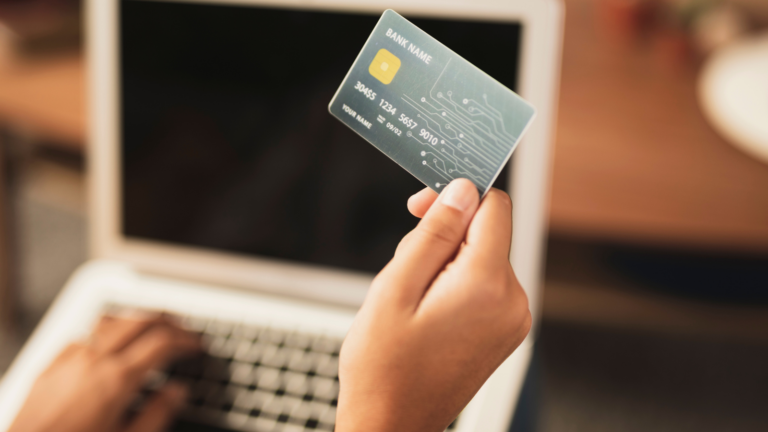 Pessoa de periferia segurando o cartão de crédito para fazer compras online