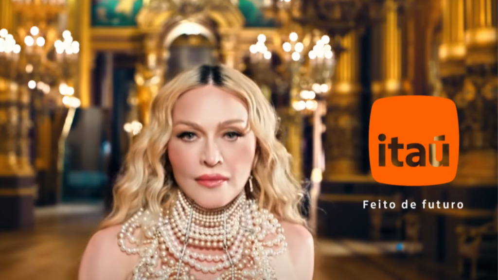 madonna usando colares de perolas ao lado do símbolo do itaú