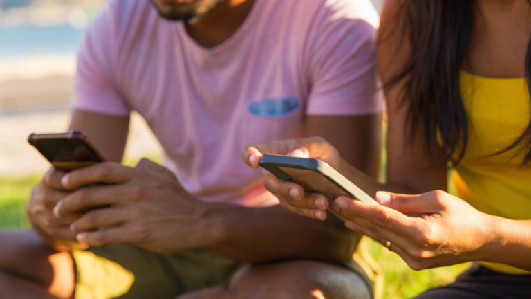 duas pessoas usando as redes sociais no celular